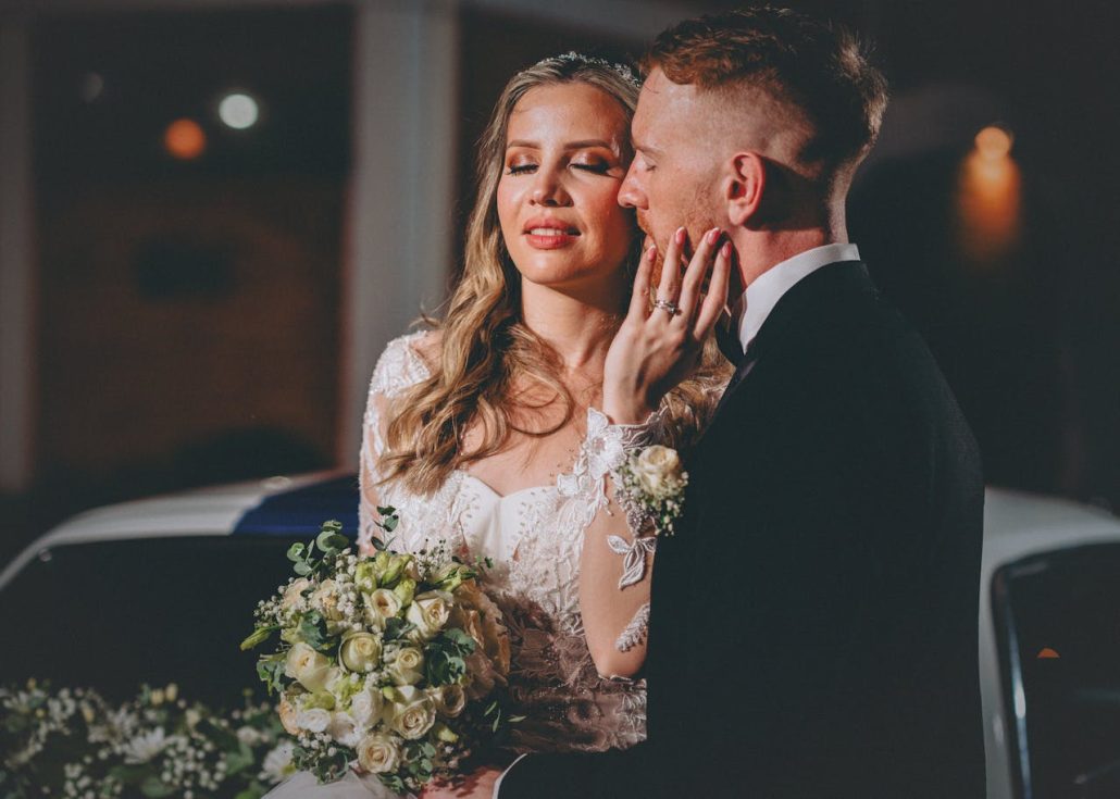 A joyful newlywed couple sharing a romantic moment outdoors at night in Asunción.